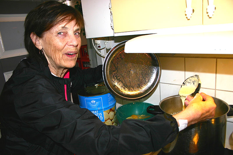 Inga-Lis Westerlund passar grytan med flötgröt som hon kokat till lunchgästerna på Trosaviks café i Hedeviken.